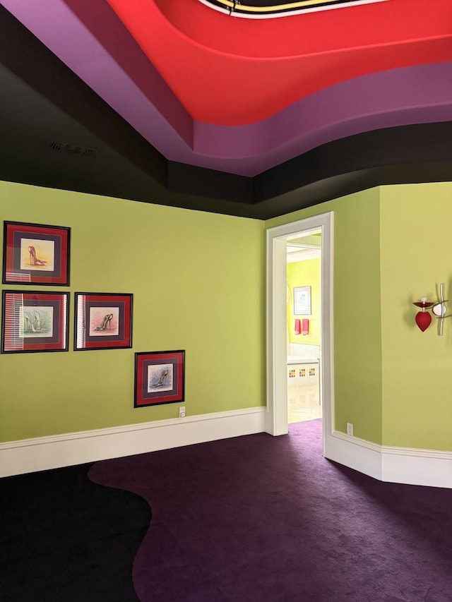 spare room featuring carpet flooring, baseboards, and visible vents