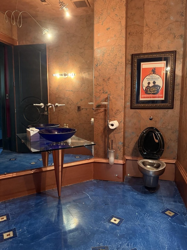 bathroom featuring toilet, visible vents, and a sink