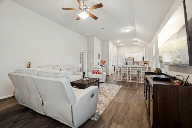 living room featuring visible vents, baseboards, ceiling fan, dark wood-style floors, and vaulted ceiling