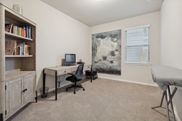 home office with baseboards and light colored carpet