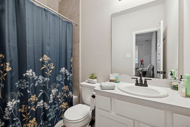 bathroom with a textured wall, shower / bathtub combination with curtain, vanity, and toilet