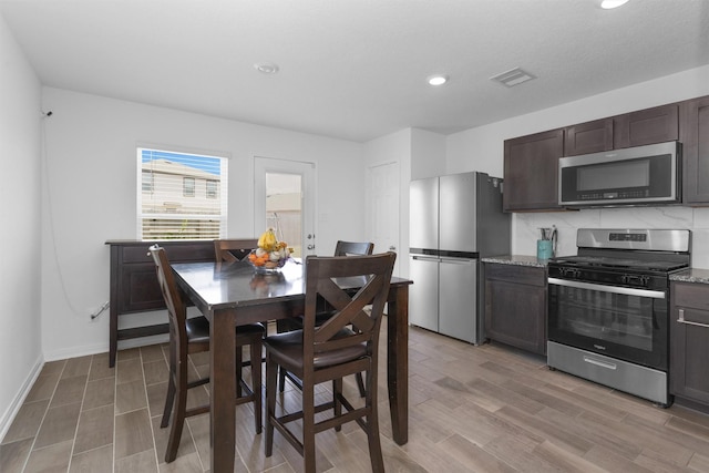kitchen with visible vents, light wood-type flooring, appliances with stainless steel finishes, dark brown cabinetry, and recessed lighting
