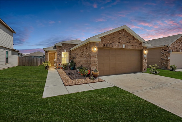 single story home featuring a garage, a lawn, fence, brick siding, and driveway