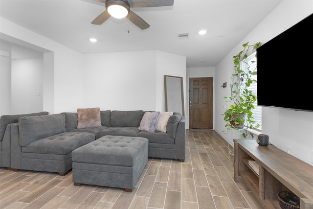 living room with light wood-style flooring, a ceiling fan, visible vents, and recessed lighting