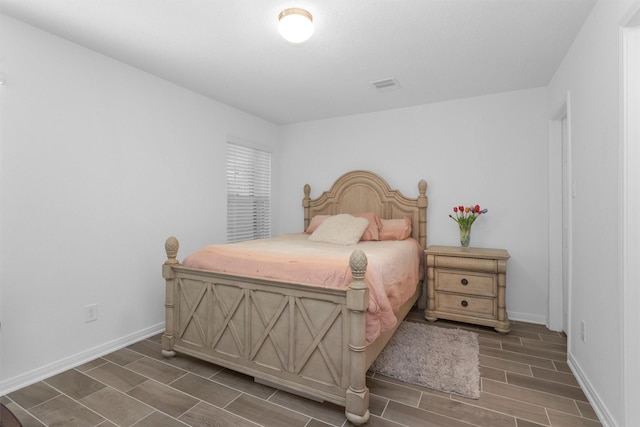bedroom with visible vents, baseboards, and wood tiled floor