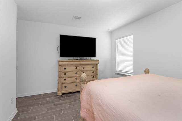 bedroom featuring dark wood-type flooring, visible vents, and baseboards