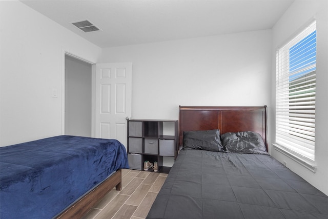 bedroom featuring visible vents and wood finish floors
