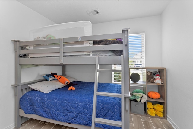 bedroom with visible vents, baseboards, and wood tiled floor