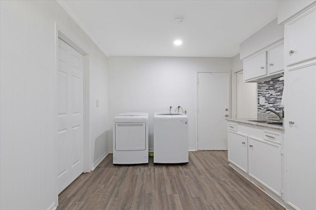 1004 Country Club Dr, Richmond, TX 77469 - clothes washing area featuring a sink, independent washer and dryer, cabinet space, and wood finished floors