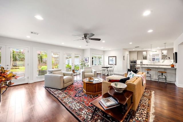 living room featuring dark wood-style floors, a ceiling fan, visible vents, and recessed lighting