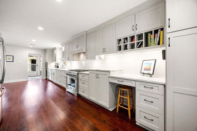 kitchen with high end stainless steel range oven, baseboards, light stone counters, recessed lighting, and dark wood finished floors