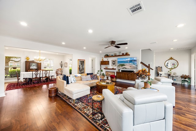 living room featuring visible vents, ceiling fan with notable chandelier, recessed lighting, and dark wood finished floors
