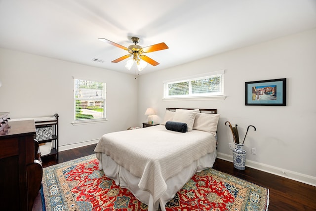 bedroom featuring ceiling fan, visible vents, baseboards, and wood finished floors