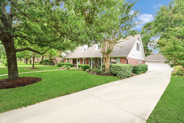 view of front of property with a detached garage, a front lawn, and brick siding