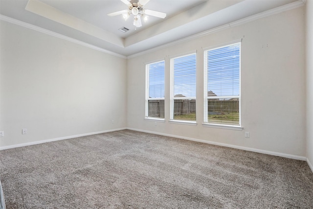 unfurnished room featuring visible vents, a raised ceiling, ornamental molding, a ceiling fan, and carpet floors