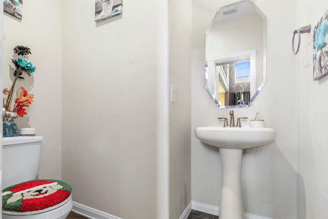 bathroom with visible vents, toilet, and baseboards