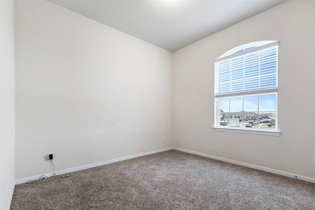 unfurnished room with plenty of natural light, baseboards, and carpet floors