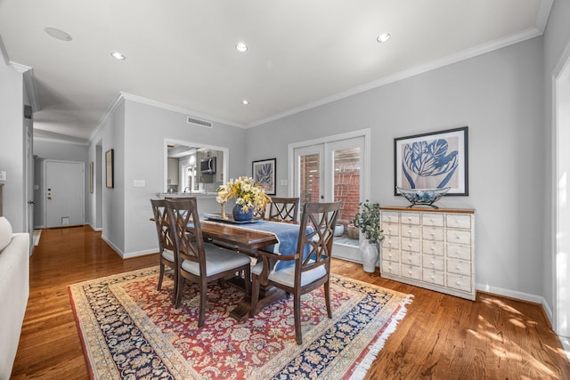 dining room featuring crown molding, visible vents, and wood finished floors