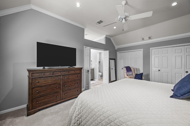 bedroom with lofted ceiling, light colored carpet, visible vents, and multiple closets