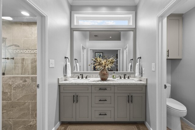 full bath with baseboards, tiled shower, and a sink