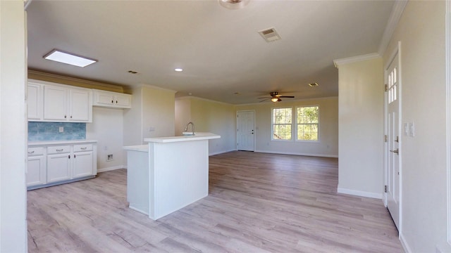kitchen with visible vents, baseboards, light countertops, crown molding, and white cabinetry