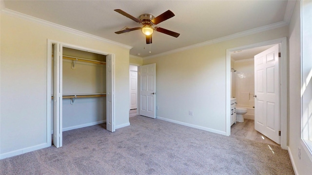 unfurnished bedroom featuring baseboards, a closet, carpet flooring, ensuite bathroom, and crown molding