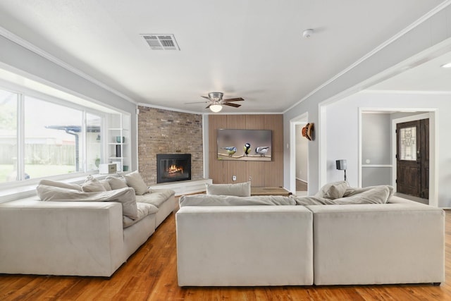 living room featuring crown molding, ceiling fan, and visible vents
