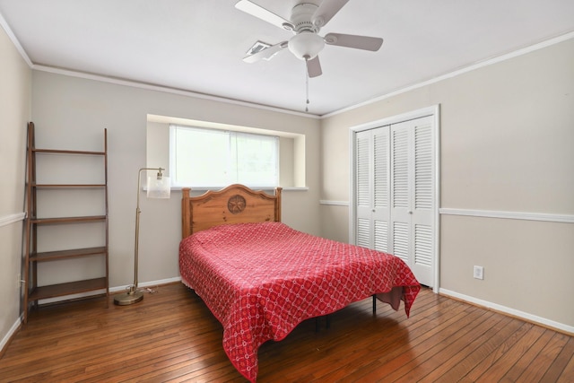bedroom with crown molding, baseboards, hardwood / wood-style flooring, and a closet
