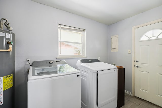 laundry room with laundry area, water heater, independent washer and dryer, and wood finished floors
