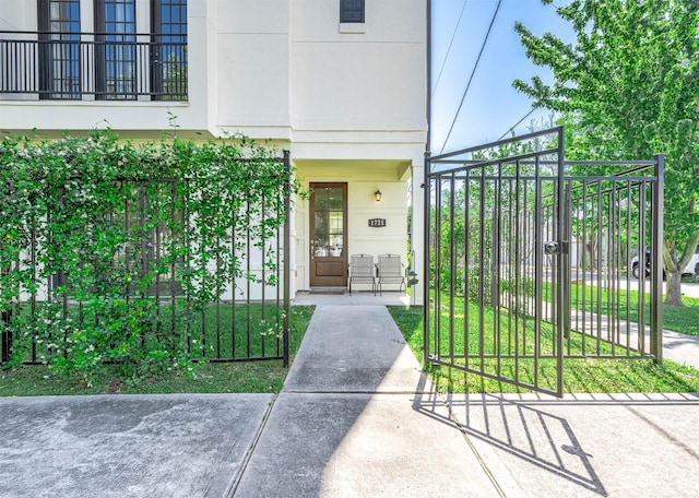 doorway to property featuring stucco siding and a gate