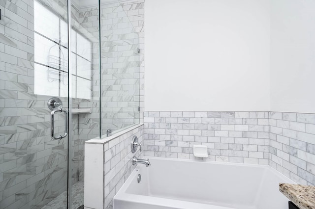 bathroom with a shower stall and a garden tub