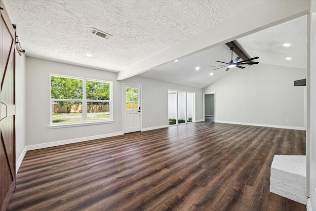 unfurnished living room featuring visible vents, baseboards, a barn door, and dark wood-style floors
