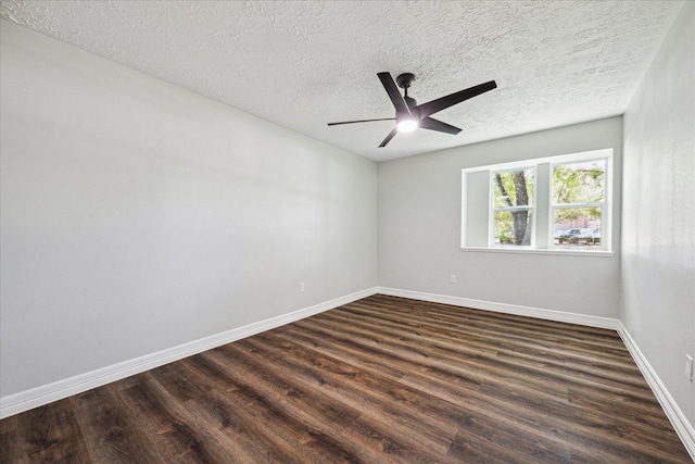 spare room with baseboards, dark wood-type flooring, a textured ceiling, and a ceiling fan