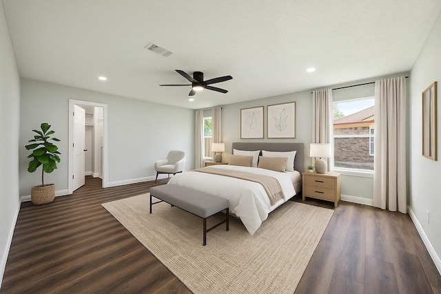 bedroom with dark wood-style floors, multiple windows, and visible vents
