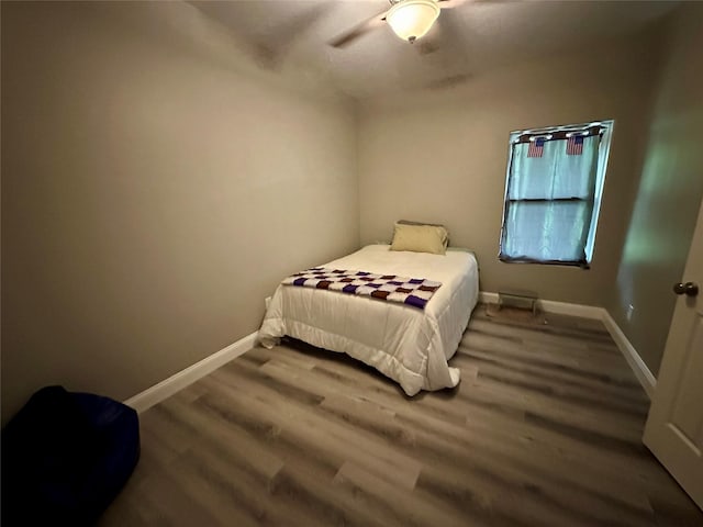 bedroom with baseboards, ceiling fan, and wood finished floors