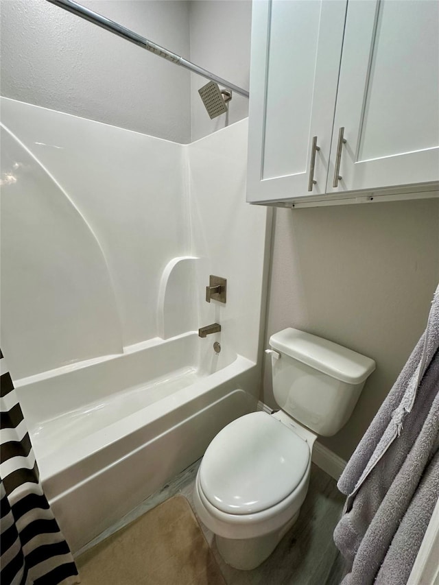 full bath featuring toilet, shower / bath combo with shower curtain, wood finished floors, and baseboards