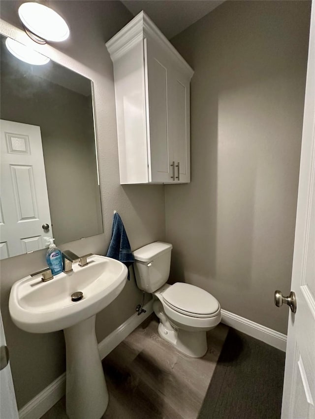 bathroom featuring baseboards, toilet, and wood finished floors