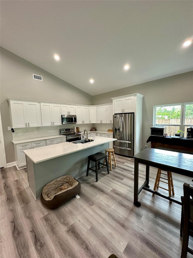 kitchen with visible vents, light countertops, vaulted ceiling, and stainless steel appliances