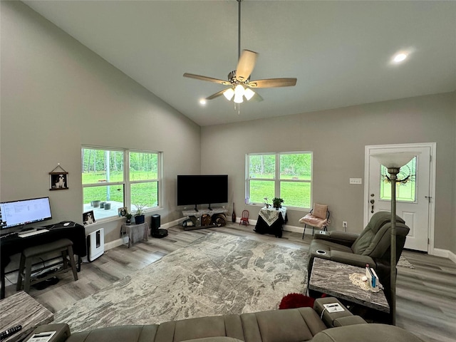 living area with baseboards, recessed lighting, ceiling fan, high vaulted ceiling, and wood finished floors