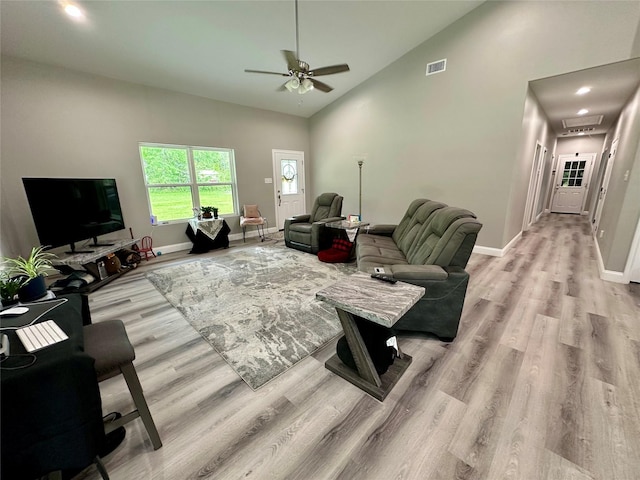 living room with visible vents, ceiling fan, light wood finished floors, and baseboards