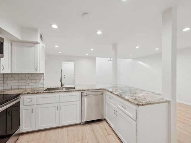 1812 Saxony Ln, Houston, TX 77058 - kitchen with appliances with stainless steel finishes, a sink, light stone countertops, white cabinets, and recessed lighting