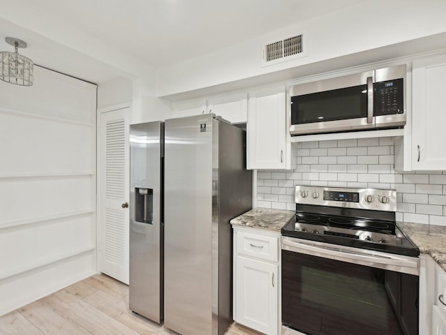 1812 Saxony Ln, Houston, TX 77058 - kitchen with stainless steel appliances, white cabinetry, light stone countertops, decorative backsplash, and light wood-type flooring