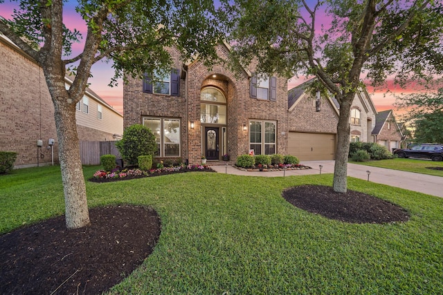 traditional-style house with a front lawn, driveway, brick siding, and fence