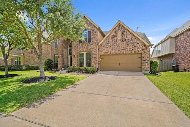 traditional-style house featuring brick siding, fence, a front yard, and concrete driveway