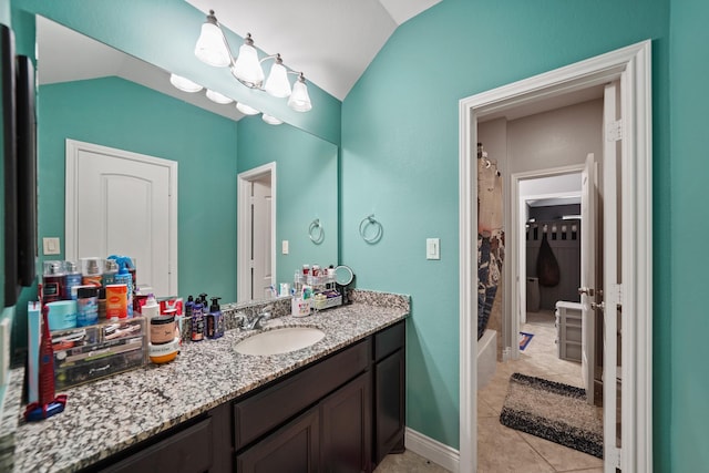 full bathroom featuring lofted ceiling, vanity, and tile patterned flooring