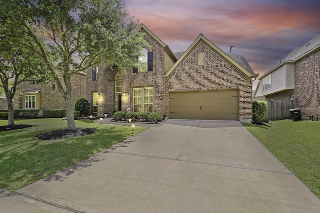 view of front of property with brick siding, fence, a front lawn, and concrete driveway