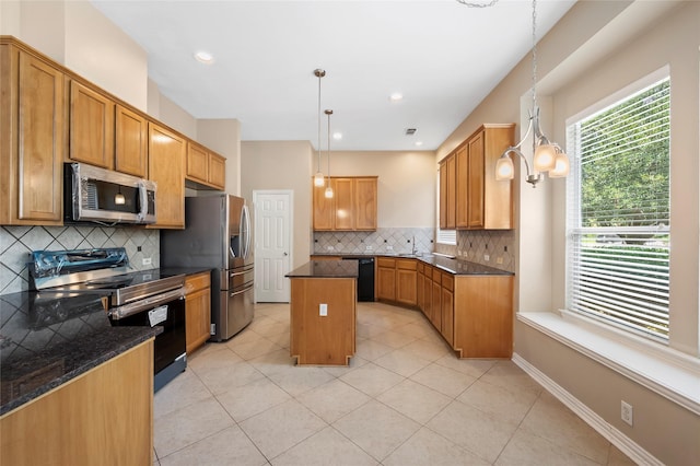 10130 Lakeside Gables Dr, Houston, TX 77065 - kitchen with light tile patterned floors, a kitchen island, appliances with stainless steel finishes, decorative light fixtures, and decorative backsplash