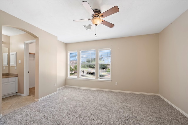 10130 Lakeside Gables Dr, Houston, TX 77065 - unfurnished room featuring arched walkways, light colored carpet, baseboards, and a ceiling fan