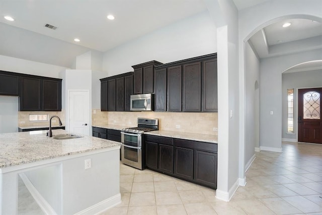 4813 Loures Ln, League City, TX 77573 - kitchen featuring light stone counters, appliances with stainless steel finishes, a sink, and light tile patterned floors