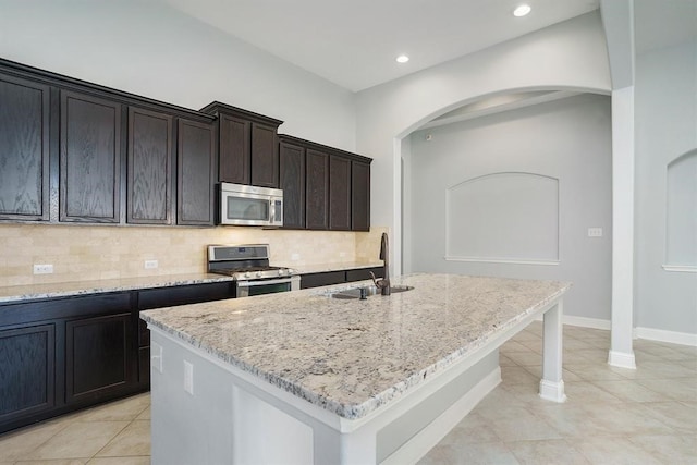 4813 Loures Ln, League City, TX 77573 - kitchen featuring arched walkways, backsplash, appliances with stainless steel finishes, and a sink